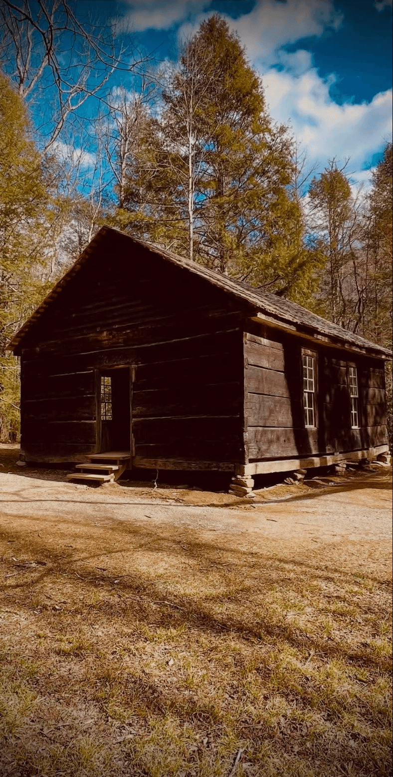 A weathered log cabin among the trees in the Smoky Mountains
